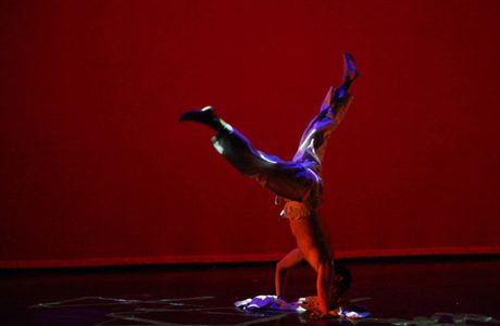 A person doing a handstand on a stage.