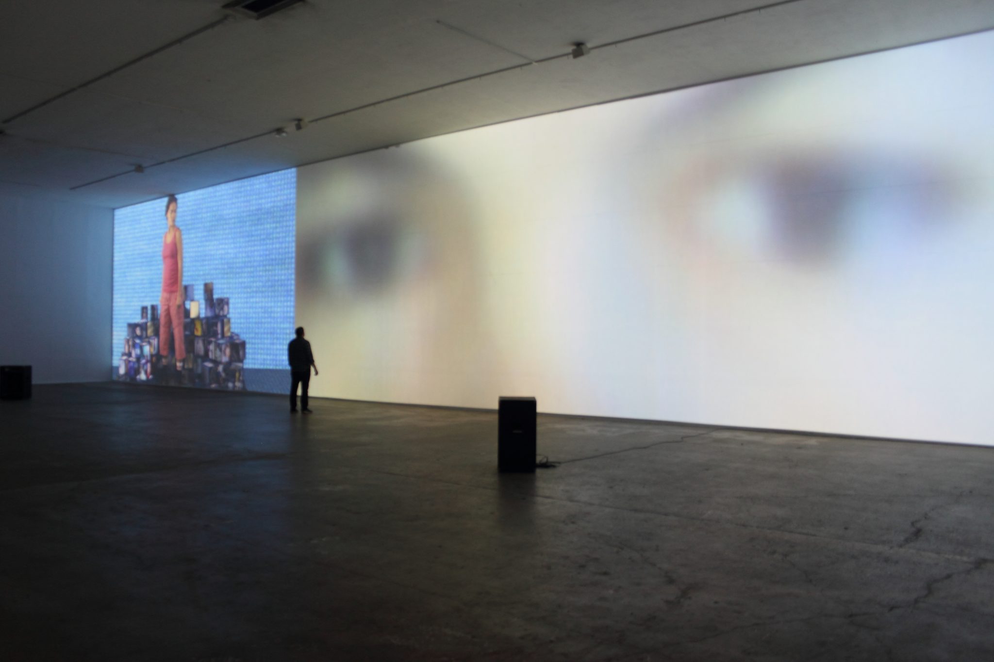 A person standing in front of a large projection screen.