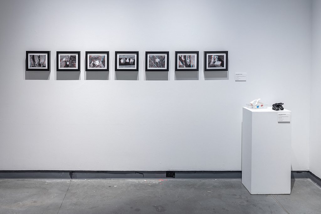 A white pedestal with framed photographs on it.