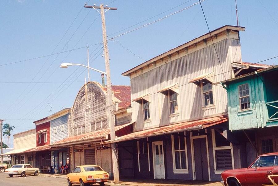 yellow car and red car in front of a street store front with general store sign from the 1950's in California