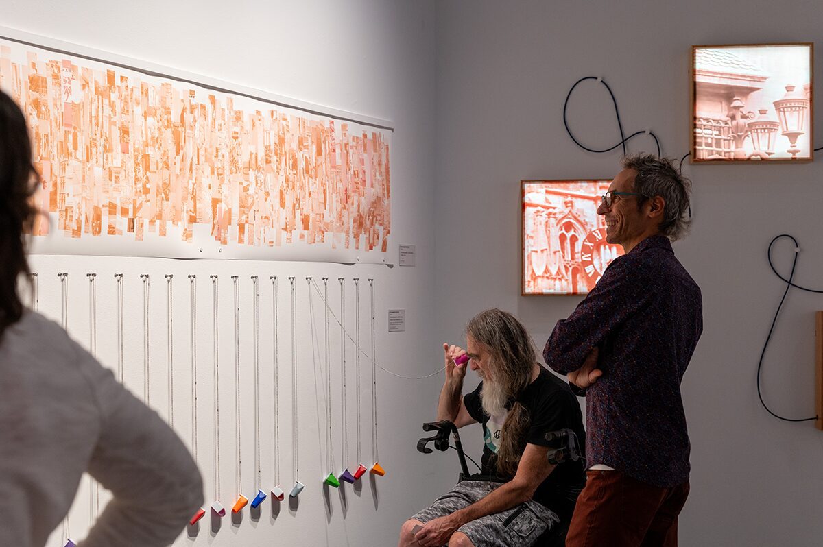 Two men in a gallery looking at art.